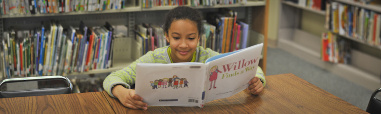 A young girl reads "Willow Finds a Way"